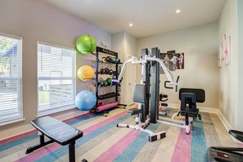 Mandarin Bay Apartment Complex Gym in Jacksonville, Fl with exercise balls, weights, and a colorful floor